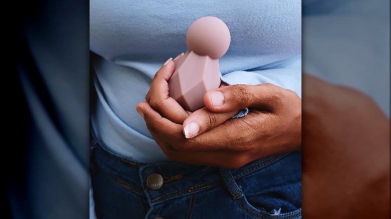 A woman holding a That Sassy Thing vibrator 