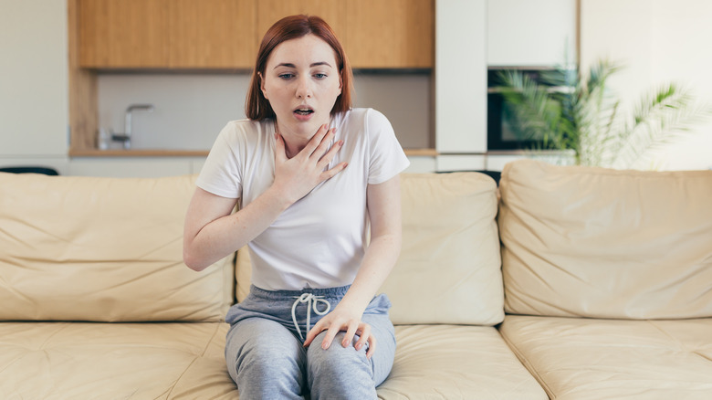 Woman holding her hand to her chest in panic