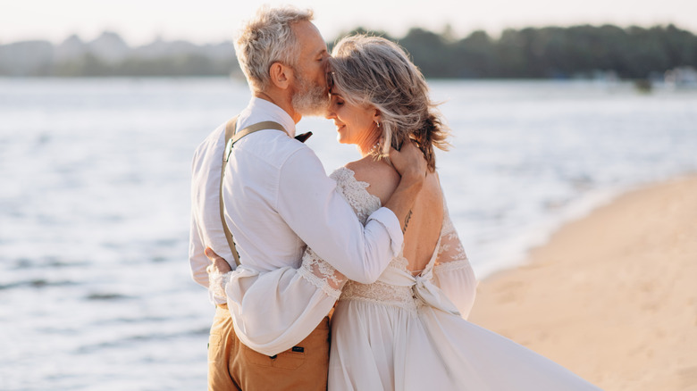 Couple kiss on wedding day at beach