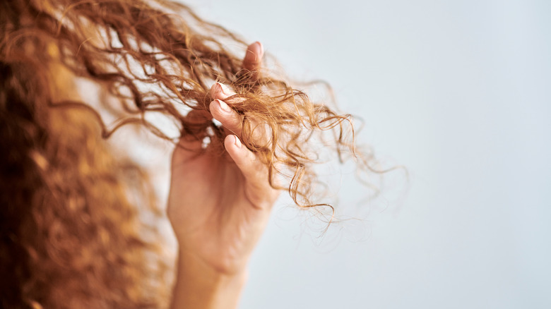 Woman touching dry hair