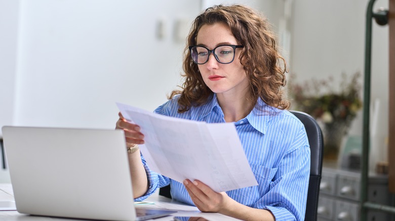 Woman in front of laptop with papers