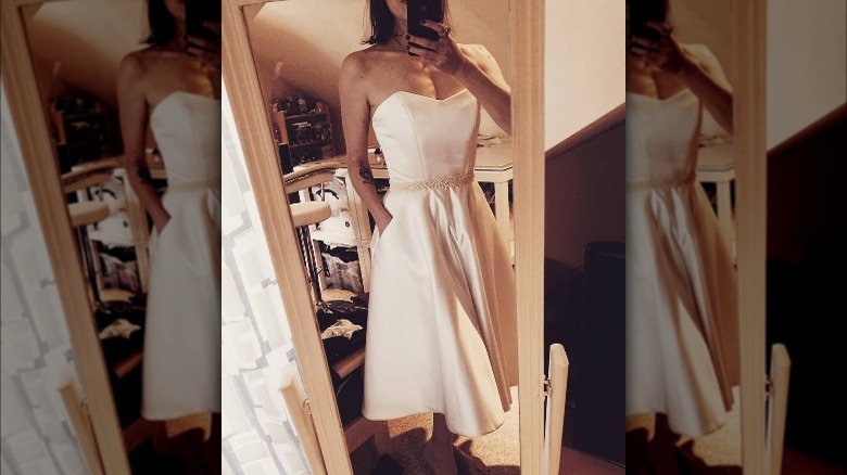Woman in short wedding dress taking selfie