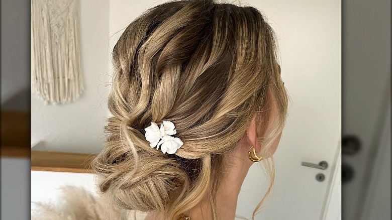 A woman with a low bun and flowers