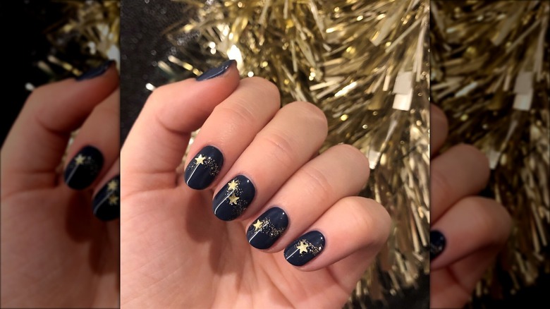 Navy manicure with gold sparkles and stars