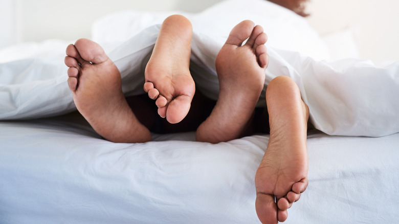 couple's feet on bed