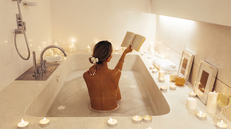 Woman reading book in bath
