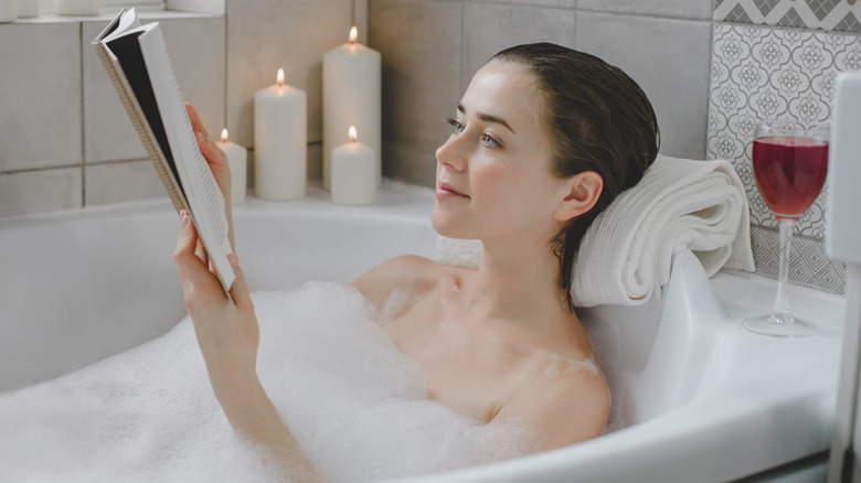 Woman reading in tub