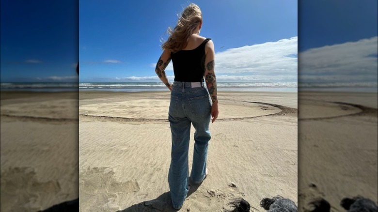 A woman wearing jeans on the beach
