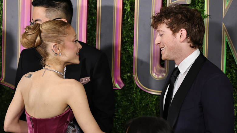 Ariana Grande and Ethan Slater talking to each other on the red carpet