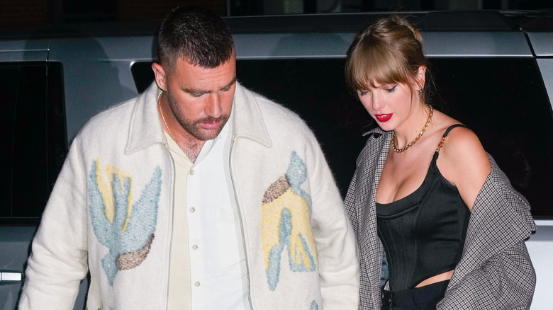 Paprazzi shot of Taylor Swift and Travis Kelce getting out of an SUV