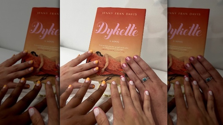 Four hands touching "Dykette" book