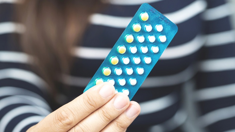 Hand holding pack of birth control pills