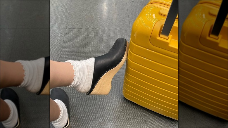 Clog shoes set against a suitcase