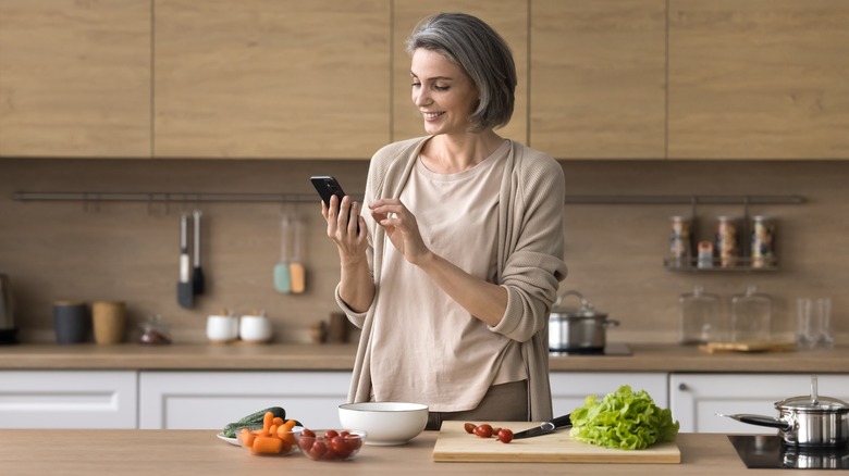 An older woman prepares a healthy meal of fruits and veggies