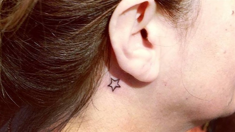 Star tattoo behind the ear