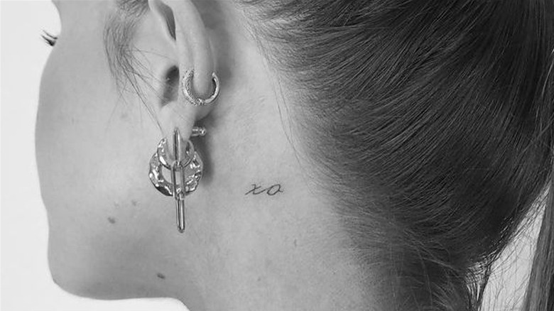 XO behind the ear tattoo