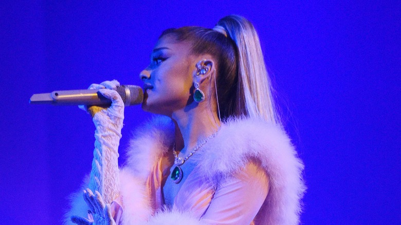 Arian Grande holding a microphone during performance