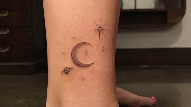 Billie Lourd ankle with moon, stars, and planets tattoo