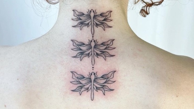 woman's neck three dragonfly tattoo