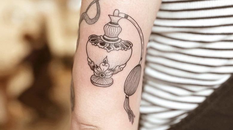 tattoo of perfume bottle on a woman's arm