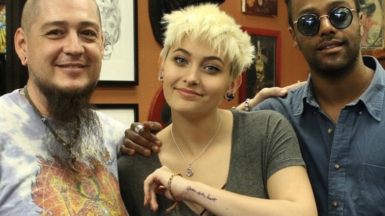 Paris Jackson with two men, showing off tattoo