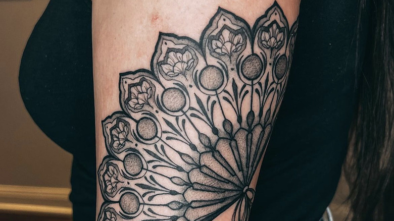 Tattoo on a woman's arm of a fan