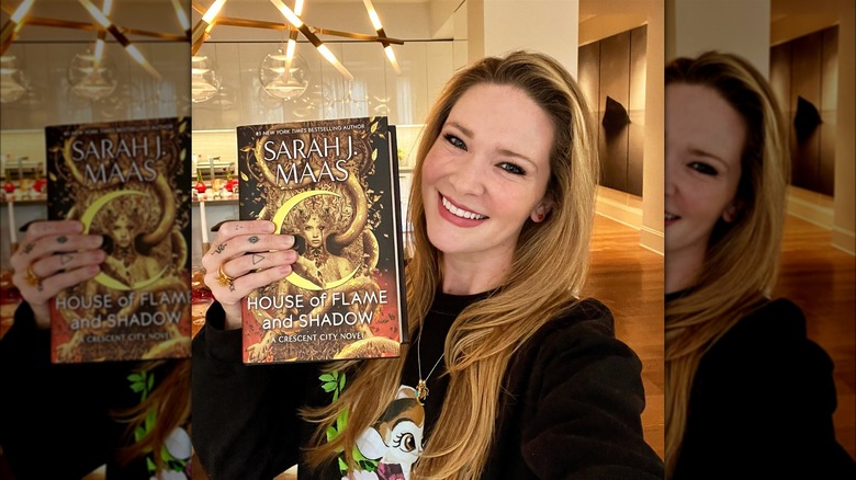 Sarah J Maas with a House of Flame and Shadow book
