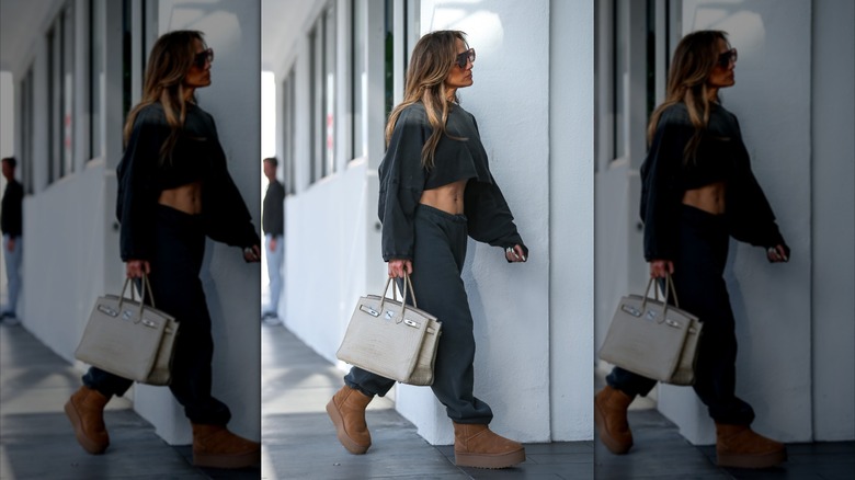 Jennifer Lopez walking in a sweatsuit and Uggs