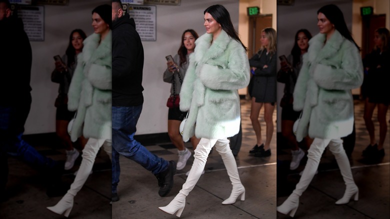 Kendall Jenner in white boots and a mint green coat