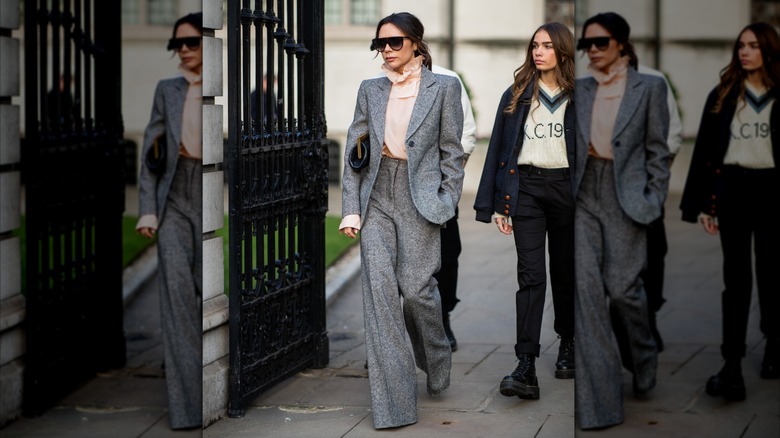 VIctoria Beckham in a grey suit and pink ruffle blouse with sunglasses at an event