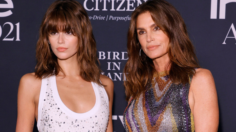 Kaia Gerber and Cindy Crawford looking off-frame while posing together