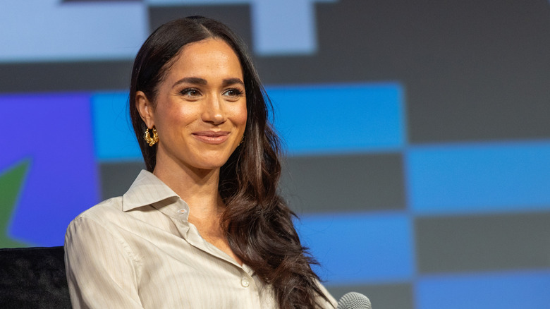 Meghan Markle at an event in a cream top