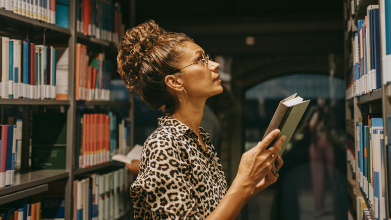 Woman looking through book shelves