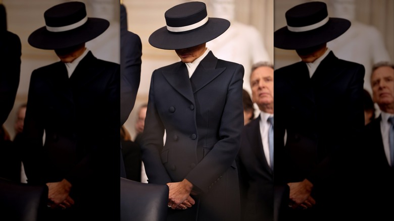 Melania Trump wearing a hat and dark suit