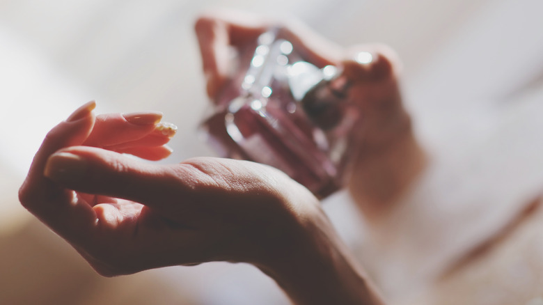 Closeup of person spraying perfume on their wrist