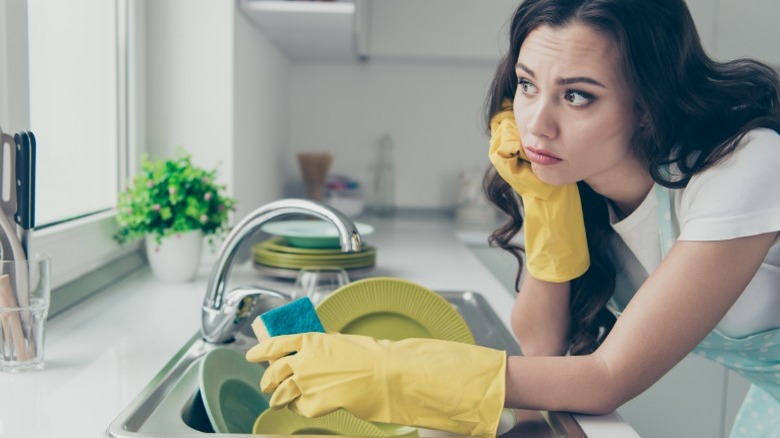 Woman sad doing dishes