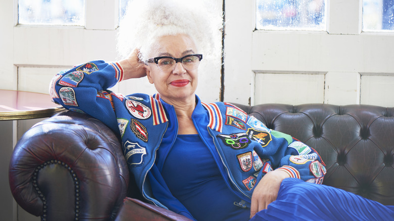 older woman lounging on a couch wearing blue