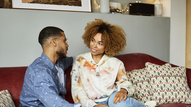 Woman and man sitting on couch talking