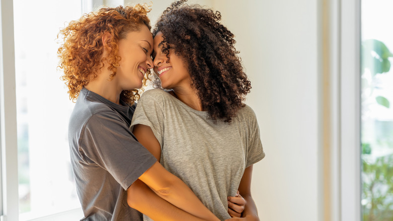 Curly-haired lesbian couple embracing