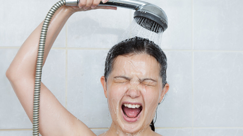 woman holding cold shower head