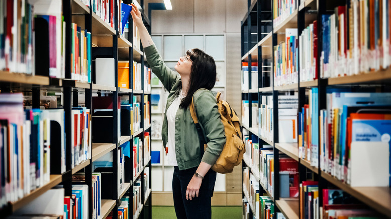 A woman picking out a book at the library