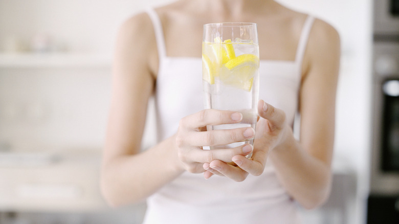 woman holding lemon water