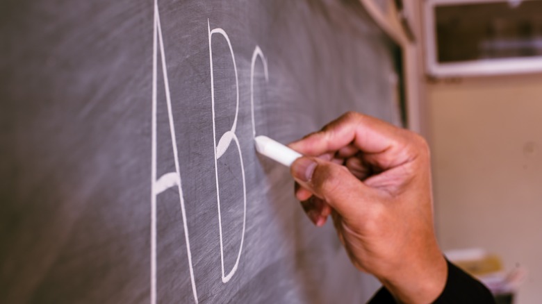 Teacher writing on the chalkboard