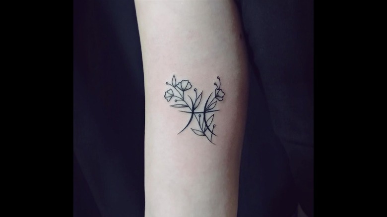 Pisces symbol with flowers tattoo