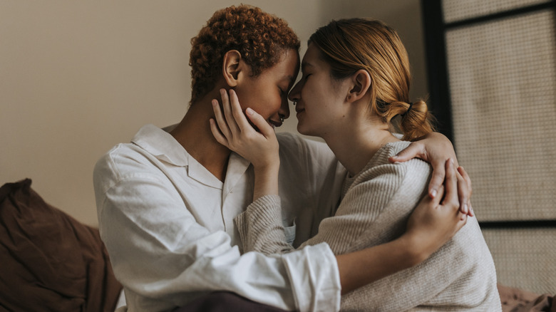 Two women embracing in bed