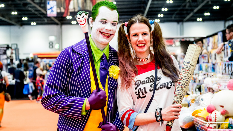 Couple at comic con dressed as the joker and harley quinn