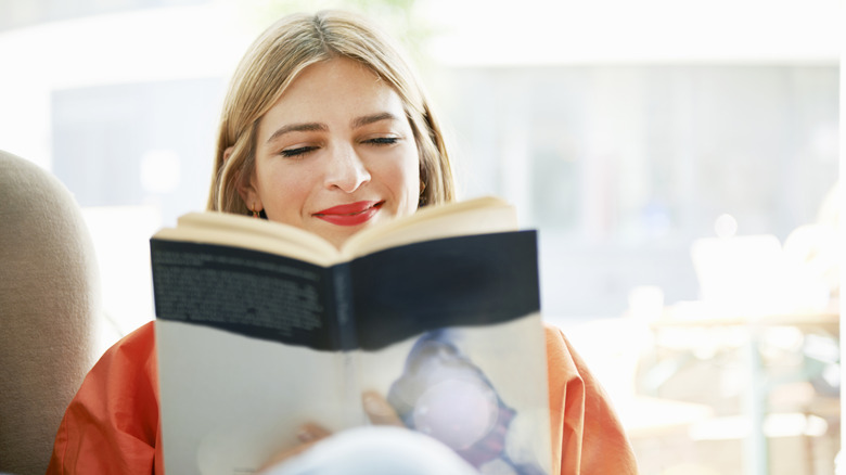 A happy woman reads a book