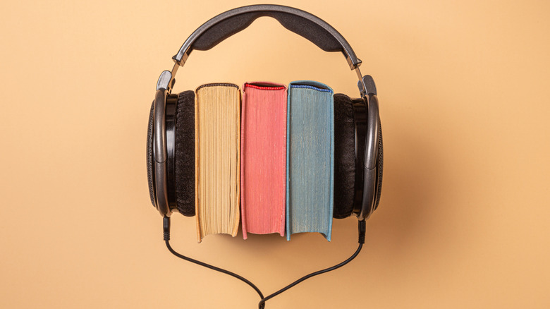 three books set side-by-side with headphones clamped around them