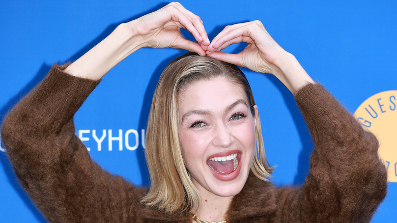 Gigi Hadid making a heart with her hands above her head