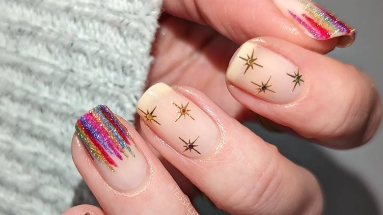 Nails with a clear base with colorful stripes coming from the tips